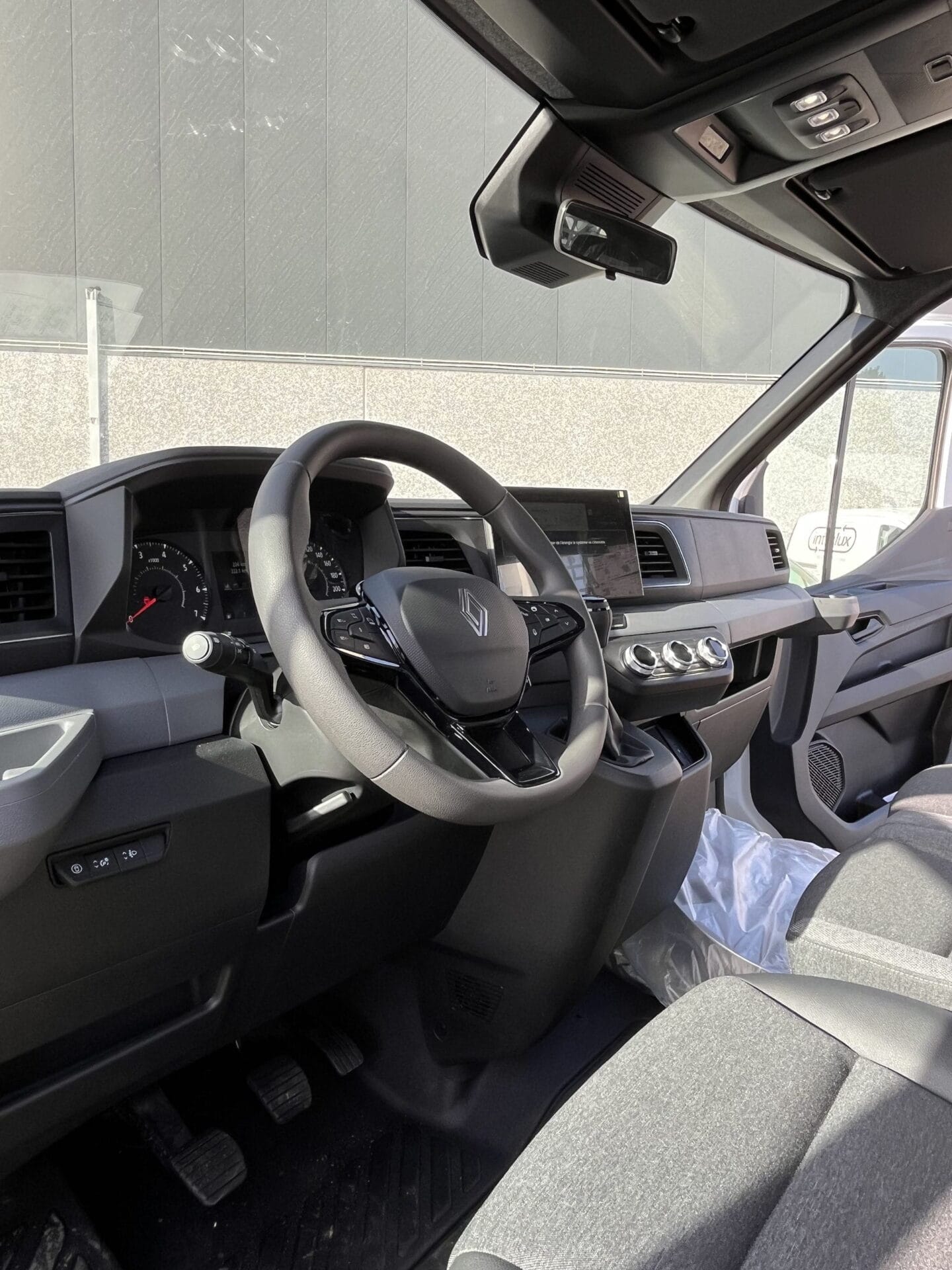 Modern vehicle interior with dashboard and steering.