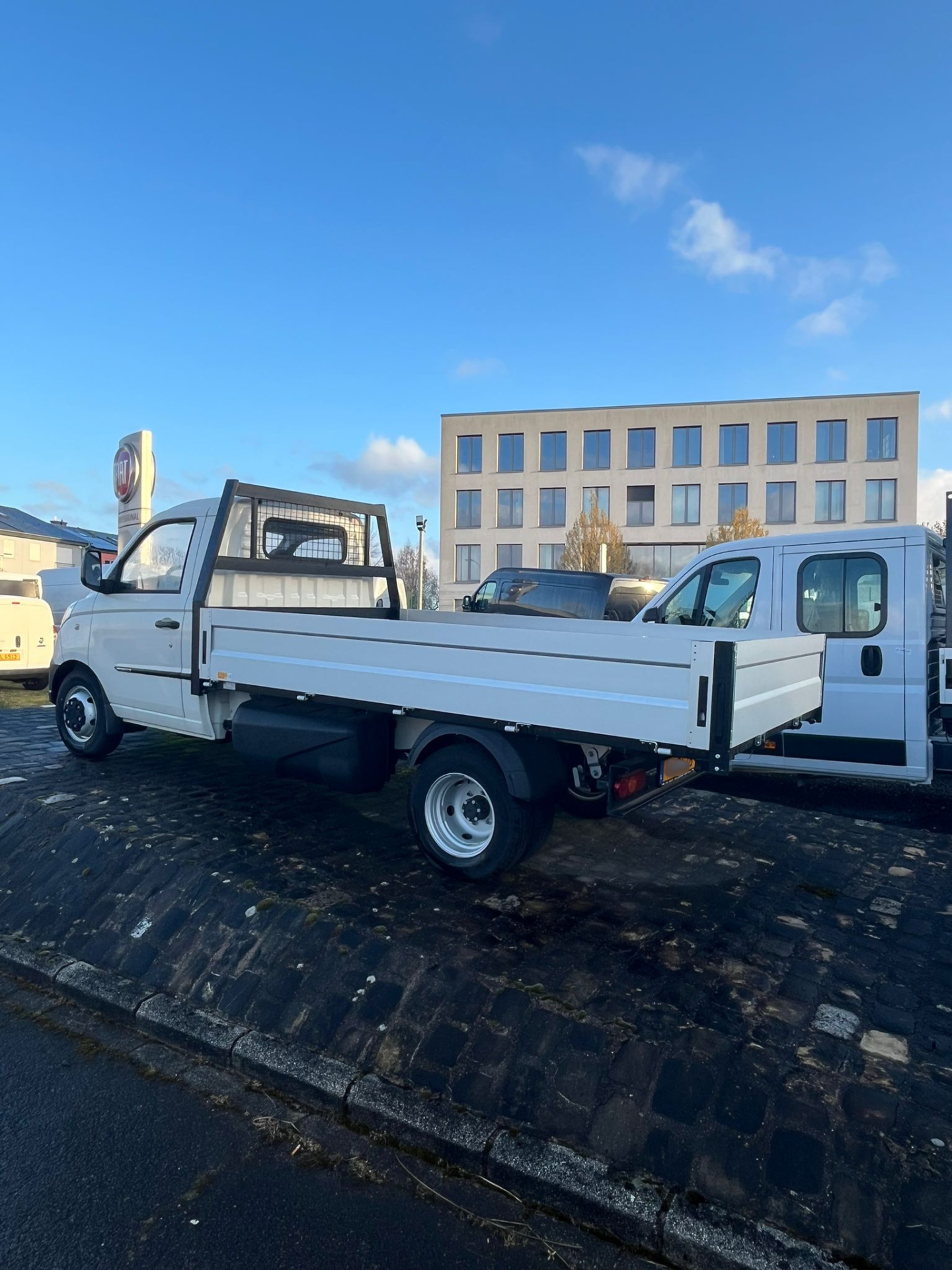 Camion blanc garé devant un immeuble