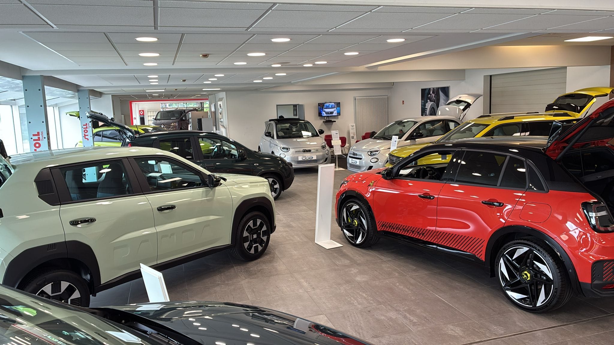 Showroom automobile avec plusieurs voitures compactes exposées