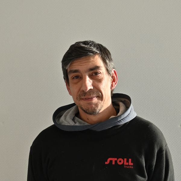 Homme souriant portant un sweat noir Stoll Trucks