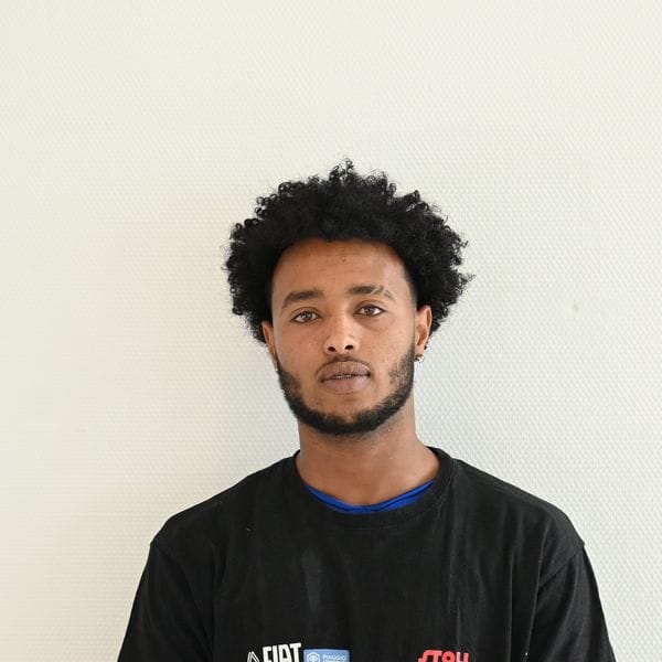 Homme portant un t-shirt noir regardant la caméra