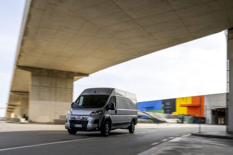 Utilitaire Fiat Ducato gris métallisé qui roule sous un pont.