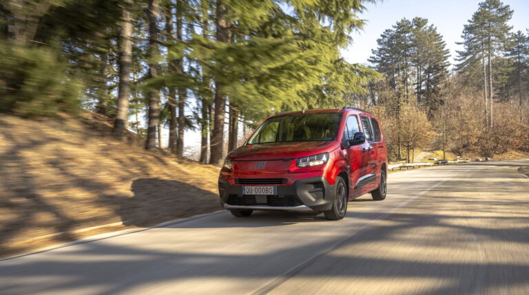 Fiat Qubol rouge sur une route en pleine nature.