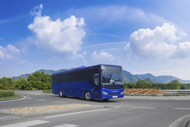 Autocar bleu Iveco sur route en montagne