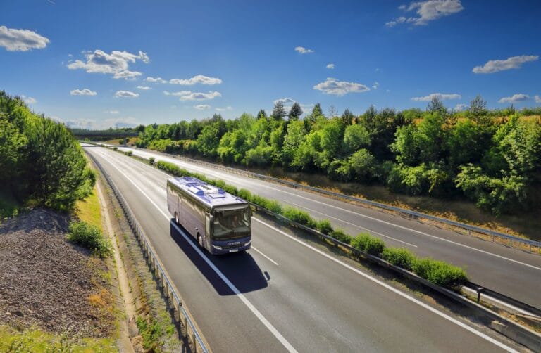 Autocar roulant sur une autoroute entourée d’arbres