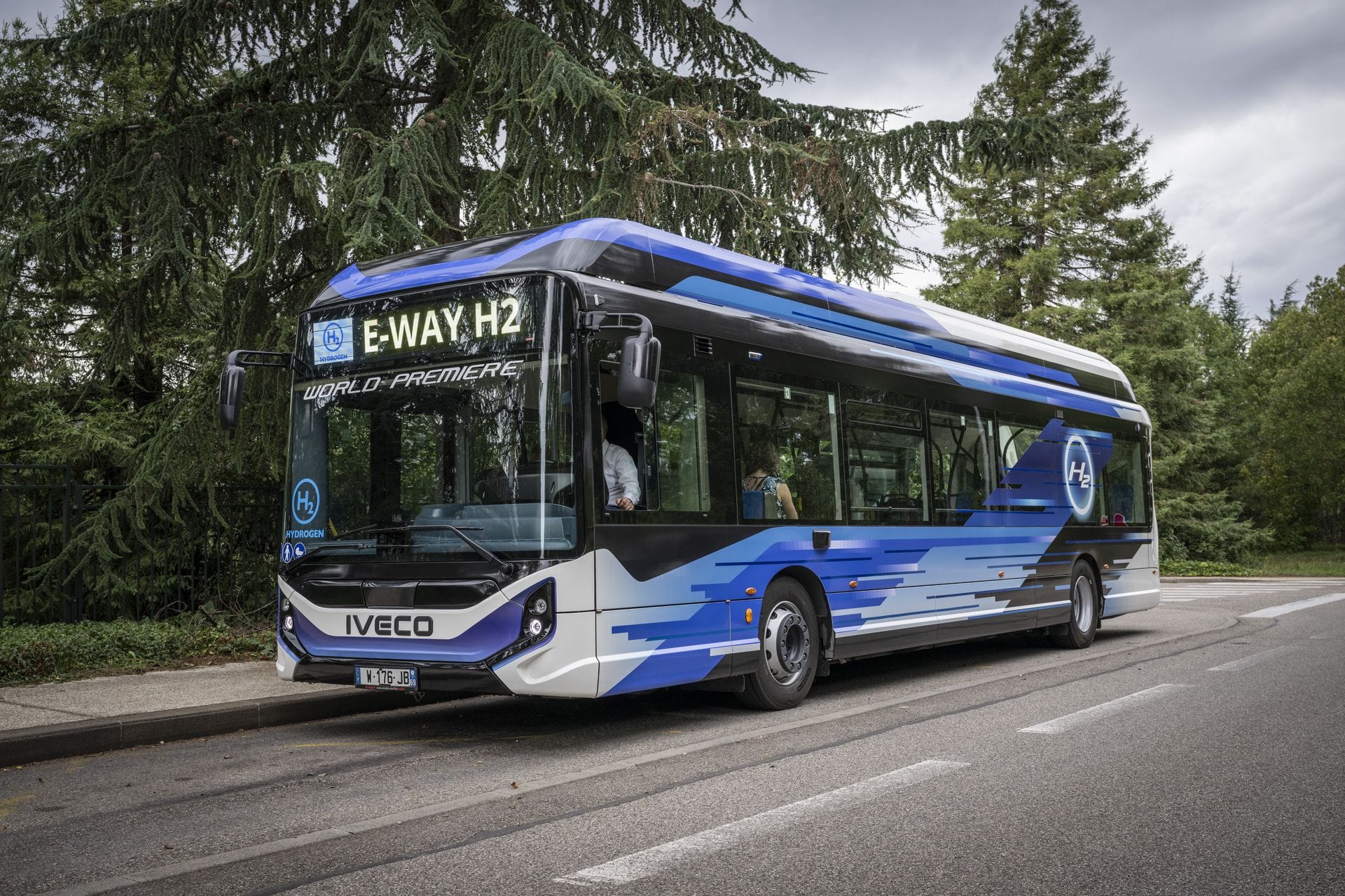 Bus Iveco à hydrogène bleu sur route arborée
