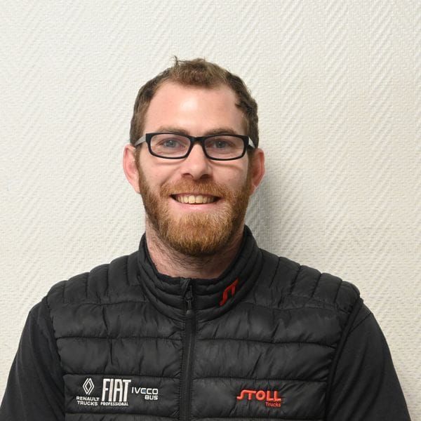 Homme souriant portant des lunettes et veste noire