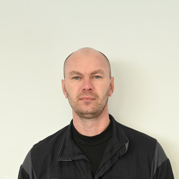 Homme debout portant une veste foncée