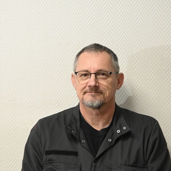 Homme portant des lunettes et veste de travail sombre