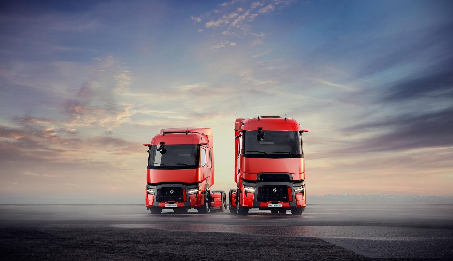 Deux camions rouges sur la route au coucher du soleil