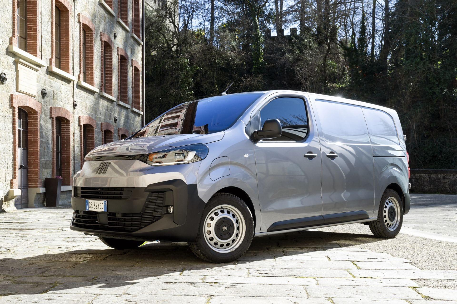 Fiat Scudo stationnée devant une bâtisse.