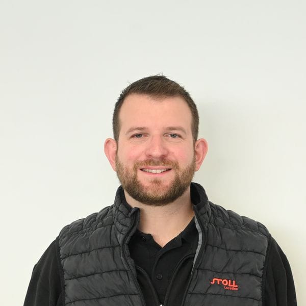 Homme souriant portant une veste noire matelassée