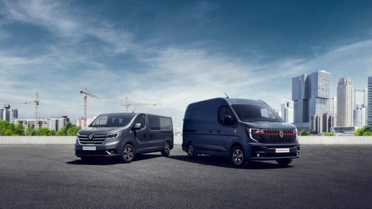 Deux fourgons Renault devant une ville moderne
