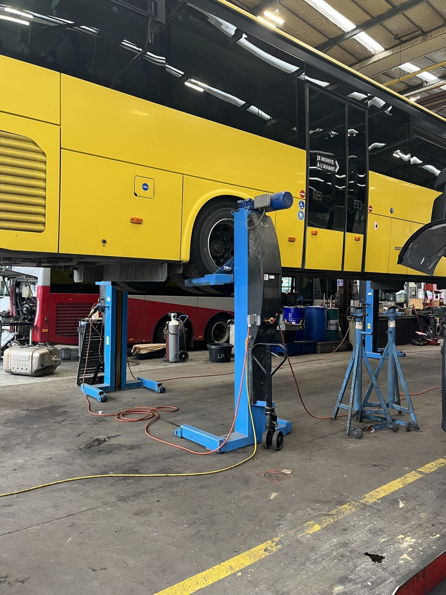 Bus jaune en réparation dans un atelier mécanique