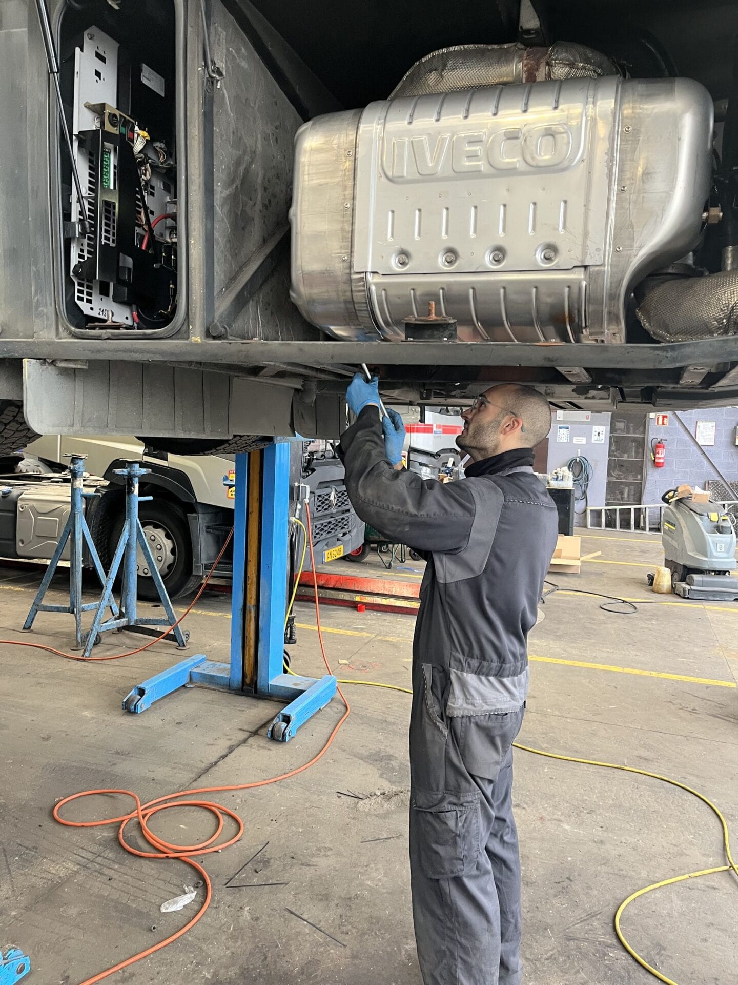 Mécanicien réparant un camion dans un atelier.