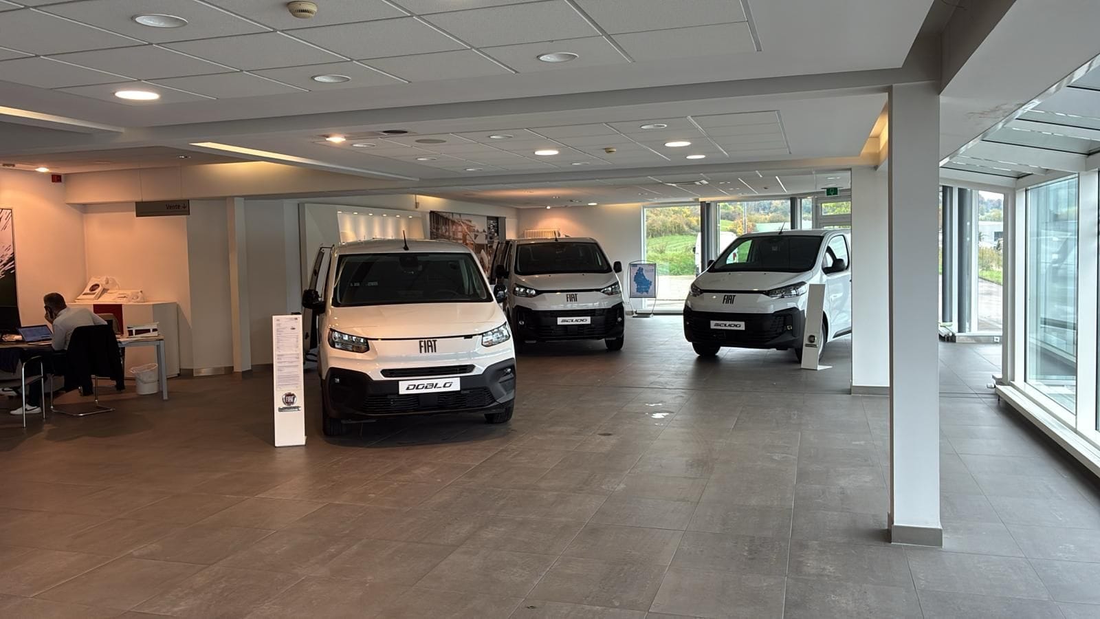 Intérieur du garage, avec des modèles utilitaires Fiat en présentation.