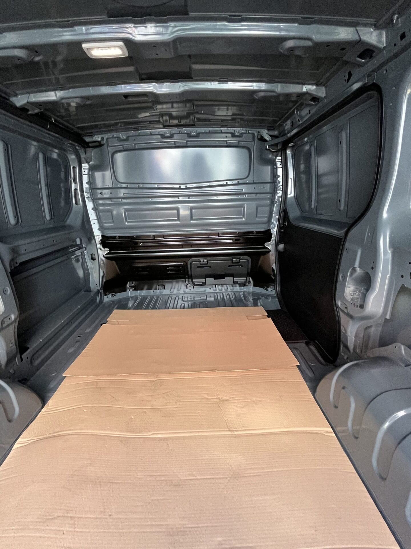 Empty van interior with cardboard floor.