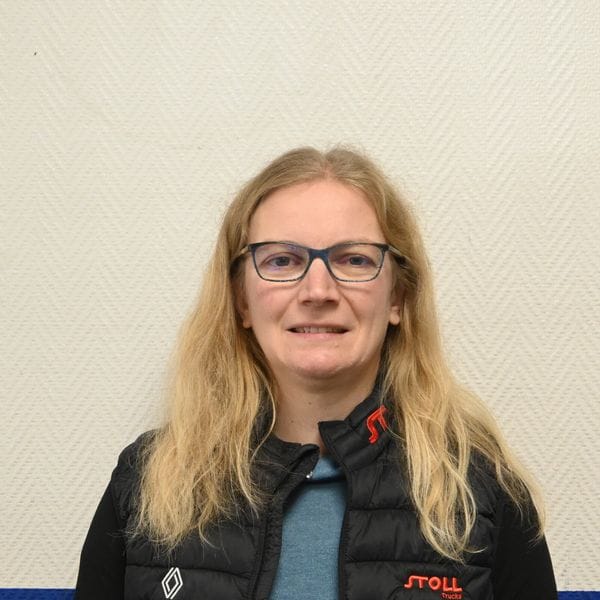 Femme blonde portant des lunettes et un gilet noir