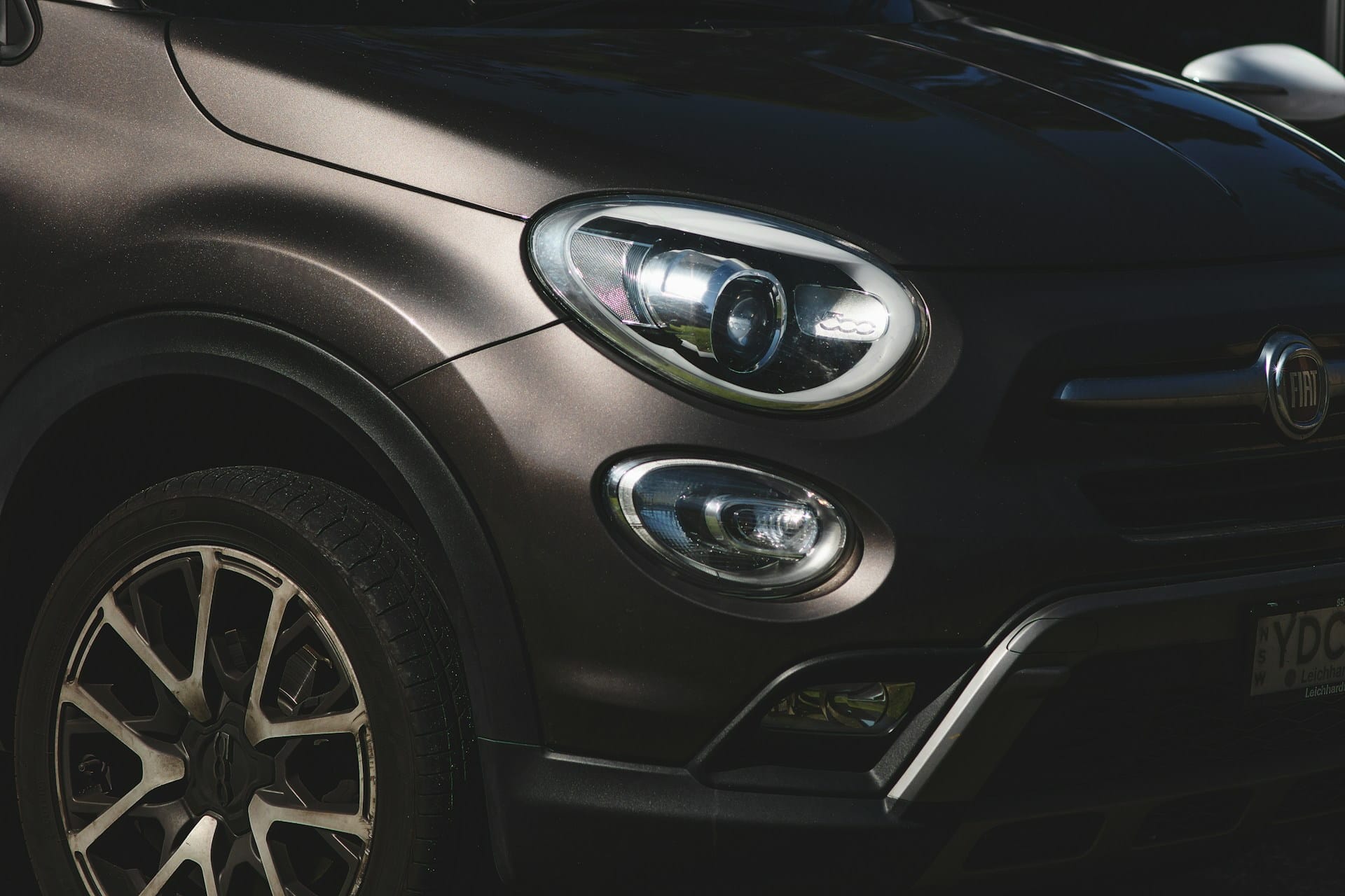 Avant d'une voiture Fiat gris foncée stationée dans un garage.
