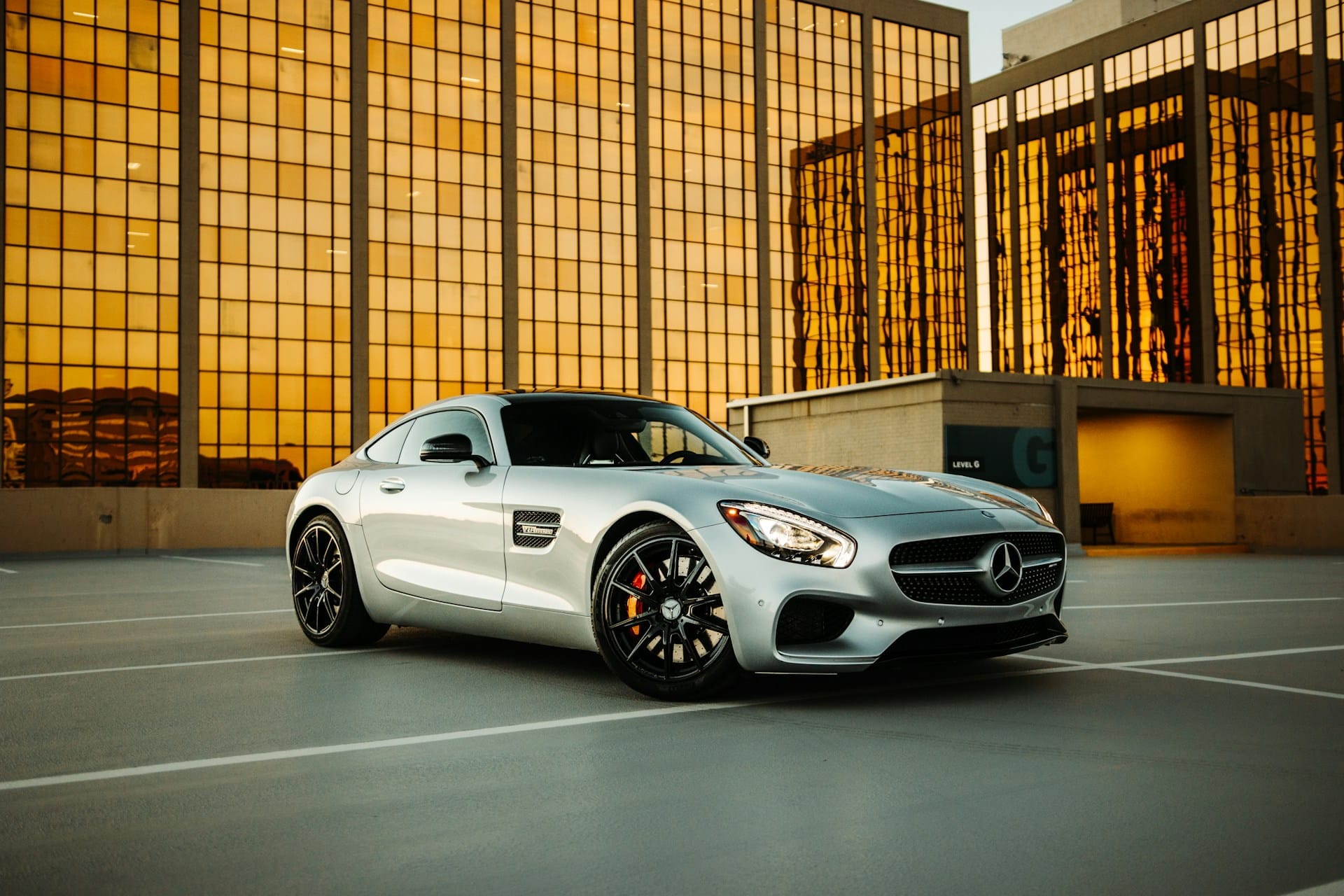 Une Mercedes en leasing stationnée seule sur un parking devant une entreprise.